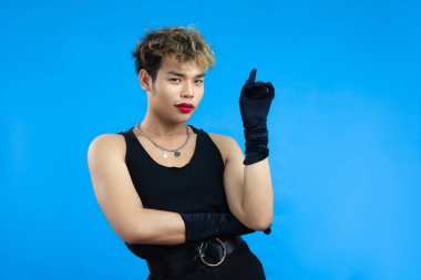 Kırmızı dudak nemlendiricisi ve siyah atletli Asyalı Transseksüel, izole edilmiş mavi arka plan oluşturuyor. Gay Gururu LGBTQ + kavramları