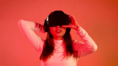 Metaverse concept, young asian woman in white shirt wearing vr headset watching playing and touching on the red background 4K video.