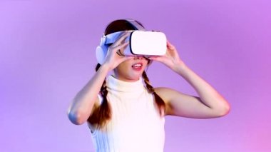 Metaverse concept, amazed young asian woman wearing white vr headset touching on the purple neon screen background. 4K video asian girl futuristic style gamer.