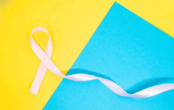 Light Pink Ribbon Breast Cancer Blue Yellow Background — Zdjęcie stockowe