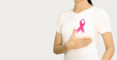 Pink badge ribbon on woman chest to support breast cancer cause. Breast cancer awareness concept. woman isolated on white background