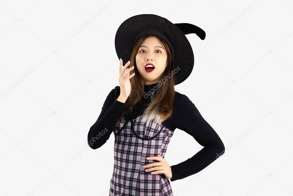 Young asian woman in witch halloween costume with hat standing and fear over white background.