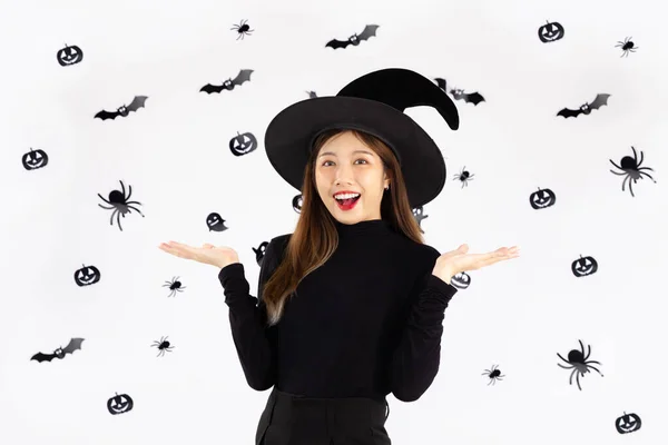ハロウィンのコンセプト 黒の衣装の若いアジアの女性は魔女の帽子を身に着けており グラフィック黒と白の背景にポーズカボチャのランタンを保持 — ストック写真
