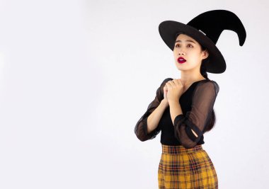 Cadılar Bayramı teması, beyaz arka planda cadı şapkası takan Asyalı genç bir kadın..