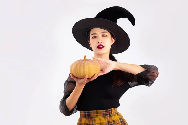 ハロウィンテーマ 若いアジア人女性で魔女衣装保持人形ポーズ上の白い背景 — ストック写真