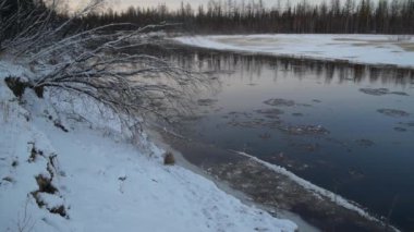 Nehir boyunca buz hareketi, gün batımında kış manzarası