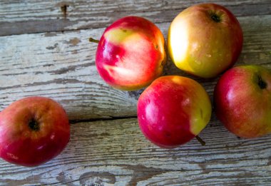 Eski ahşap bir masanın üzerine su damlayan kırmızı elmalar, kapatın, boşluğu kopyalayın