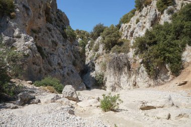 Loutani nehrinin kavrulmuş nehir yatağının çevresindeki muhteşem dağ manzarası. Kolympia, Rodos, Yunanistan 
