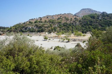Loutani nehrinin kavrulmuş nehir yatağının çevresindeki muhteşem dağ manzarası. Kolympia, Rodos, Yunanistan 