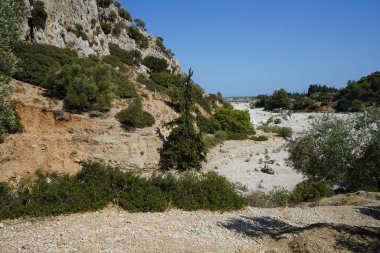 Loutani nehrinin kavrulmuş nehir yatağının çevresindeki muhteşem dağ manzarası. Kolympia, Rodos, Yunanistan 