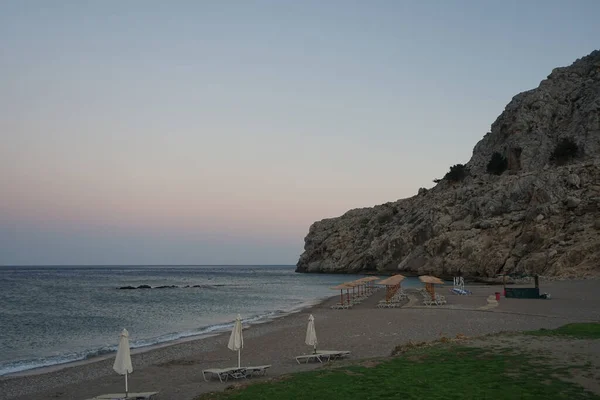 夕日の夕方にはサンラウンジャーと傘でビーチ コリンピア ロードス島 ギリシャ — ストック写真