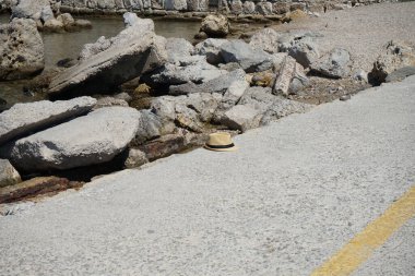 Denizin kıyısındaki bir rıhtımda kaybolmuş bir şapka. Rodos, Yunanistan 