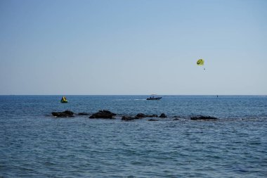 Akdeniz 'de parasailing. Parasailing, bir insanın bir aracın arkasına çekilip paraşütü andıran özel tasarlanmış bir paraşüt kanadına bağlandığı bir eğlence amaçlı uçurtma aktivitesidir. Kolimpia, Rodos, Yunanistan 