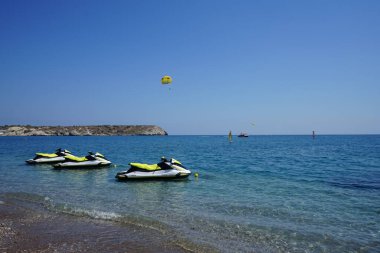 Akdeniz 'de parasailing. Parasailing, bir insanın bir aracın arkasına çekilip paraşütü andıran özel tasarlanmış bir paraşüt kanadına bağlandığı bir eğlence amaçlı uçurtma aktivitesidir. Kolimpia, Rodos, Yunanistan 