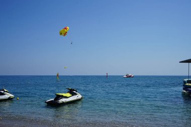 Akdeniz 'de parasailing. Parasailing, bir insanın bir aracın arkasına çekilip paraşütü andıran özel tasarlanmış bir paraşüt kanadına bağlandığı bir eğlence amaçlı uçurtma aktivitesidir. Kolimpia, Rodos, Yunanistan 