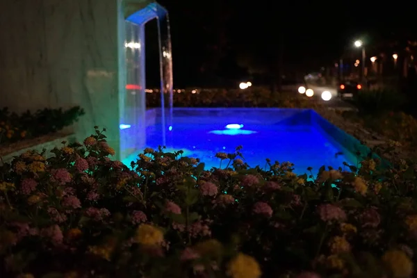 Ein Nachts Beleuchteter Brunnen Umgeben Von Blumenbeeten Von Lantana Camara — Stockfoto