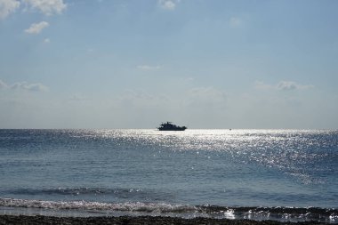 Deniz ufkunda güneş ışınlarında bir yat. Kolimpia, Rodos, Yunanistan 