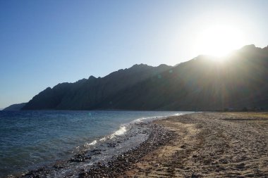 Kızıl Deniz kıyısında dağın arkasında gün batımı. Dahab, Güney Sina Valiliği, Mısır 