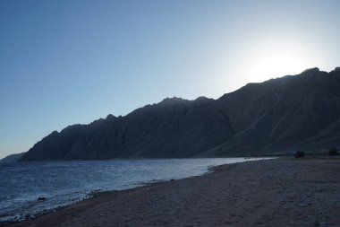 Kızıl Deniz kıyısında dağın arkasında gün batımı. Dahab, Güney Sina Valiliği, Mısır 