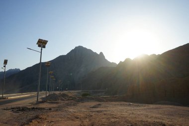 Gün batımında otoyol boyunca güneş lambaları. Yeşil enerji. Dahab, Güney Sina Valiliği, Mısır 