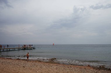 Kızıl Deniz 'de Akabe Körfezi' nde kırmızı yelkenli bir rüzgar sörfçüsü. Rüzgâr sörfü, sörf ve yelkenciliğin birleşiminden oluşan bir su sporudur. Dahab, Güney Sina Valiliği, Mısır  