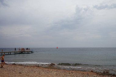 Kızıl Deniz 'de Akabe Körfezi' nde kırmızı yelkenli bir rüzgar sörfçüsü. Rüzgâr sörfü, sörf ve yelkenciliğin birleşiminden oluşan bir su sporudur. Dahab, Güney Sina Valiliği, Mısır  