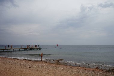 Kızıl Deniz 'de Akabe Körfezi' nde kırmızı yelkenli bir rüzgar sörfçüsü. Rüzgâr sörfü, sörf ve yelkenciliğin birleşiminden oluşan bir su sporudur. Dahab, Güney Sina Valiliği, Mısır  