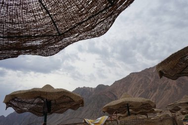 Güneşin kumsaldaki hasır şemsiyesi. Dahab, Güney Sina Valiliği, Mısır  