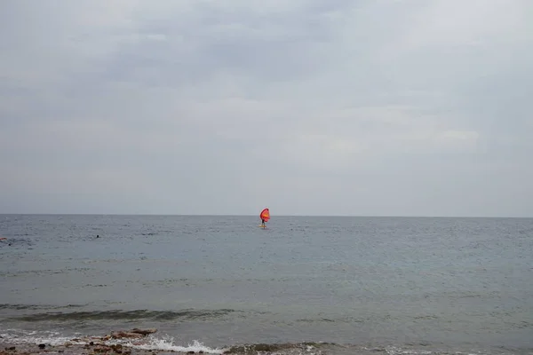 アカバ湾の紅海に赤い帆を持つウィンドサーファー ウィンドサーフィンはサーフィンとセーリングの組み合わせである水上スポーツです エジプト南シナイ県ダハブ — ストック写真