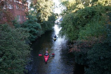 Schlossgraben 'de iki kano denize açılıyor. Baidarka ya da Aleutian kanosu sert bir uzay çerçevesi üzerinde yumuşak deriden oluşan bir su gemisidir. Berlin, Almanya 