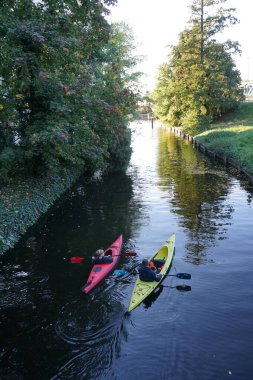Schlossgraben 'de iki kano denize açılıyor. Baidarka ya da Aleutian kanosu sert bir uzay çerçevesi üzerinde yumuşak deriden oluşan bir su gemisidir. Berlin, Almanya 