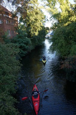 Schlossgraben 'de iki kano denize açılıyor. Baidarka ya da Aleutian kanosu sert bir uzay çerçevesi üzerinde yumuşak deriden oluşan bir su gemisidir. Berlin, Almanya 