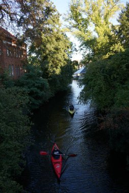Schlossgraben 'de iki kano denize açılıyor. Baidarka ya da Aleutian kanosu sert bir uzay çerçevesi üzerinde yumuşak deriden oluşan bir su gemisidir. Berlin, Almanya 