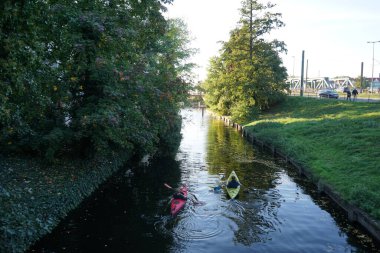 Schlossgraben 'de iki kano denize açılıyor. Baidarka ya da Aleutian kanosu sert bir uzay çerçevesi üzerinde yumuşak deriden oluşan bir su gemisidir. Berlin, Almanya 