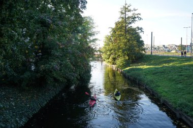 Schlossgraben 'de iki kano denize açılıyor. Baidarka ya da Aleutian kanosu sert bir uzay çerçevesi üzerinde yumuşak deriden oluşan bir su gemisidir. Berlin, Almanya 