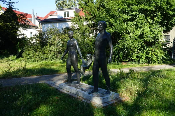 ハンス デトレフ ヘニッヒによるブロンズ彫刻 Family は1965年からエルンスト グルーベ ストラースで制作された 幼い娘を三角形のショールの上に寝そべって揺らしている2人の幼い両親の姿が描かれている ドイツ ベルリン — ストック写真