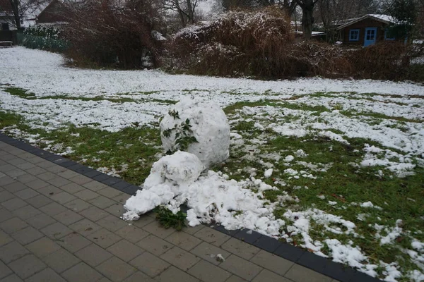 A snowball from a melted snowman on the lawn in December. Berlin, Germany