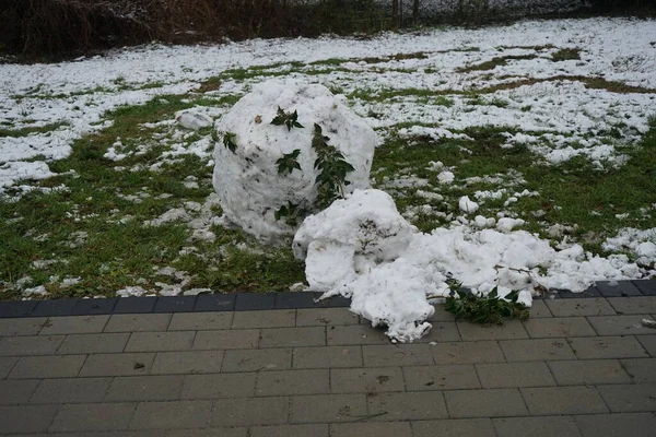 A snowball from a melted snowman on the lawn in December. Berlin, Germany