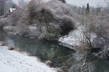 Aralık ayında kar altında Wuhle nehrinin resimli kıyıları. Berlin, Almanya