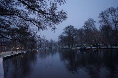 Nehrin karlı kıyıları Aralıkta akşam vakti Spree. Berlin, Almanya
