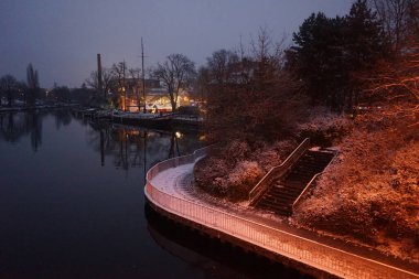 Snowy banks of the river Spree in the evening in December. Berlin, Germany