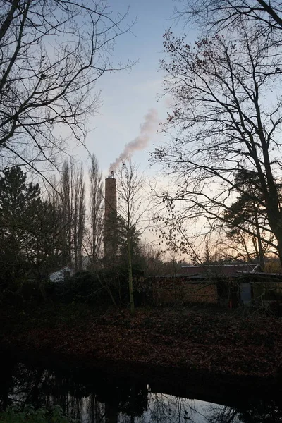 Smoke from a chimney from a boiler house against the sky at sunset in November.  Berlin, Germany