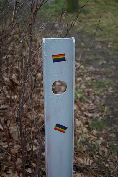 Boundary post on the road with the flag of the LGBT community. The rainbow flag is a symbol of lesbian, gay, bisexual, transgender LGBT and queer pride and LGBT social movements. Berlin, Germany