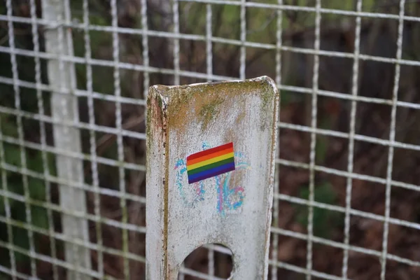 Boundary post on the road with the flag of the LGBT community. The rainbow flag is a symbol of lesbian, gay, bisexual, transgender LGBT and queer pride and LGBT social movements. Berlin, Germany