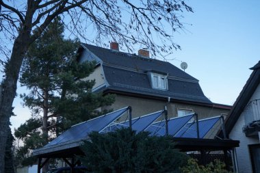 Solar panels on the roof of a wooden carpot for a car. Berlin, Germany 