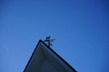 A metal rooster on the roof of the house indicates the direction of the wind. Berlin, Germany