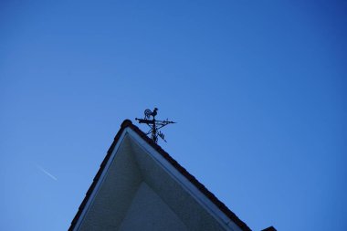 A metal rooster on the roof of the house indicates the direction of the wind. Berlin, Germany