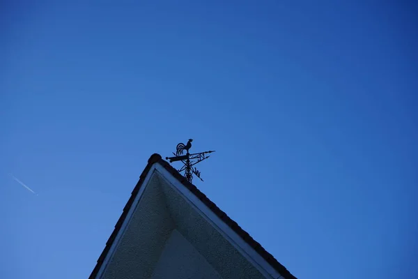 A metal rooster on the roof of the house indicates the direction of the wind. Berlin, Germany