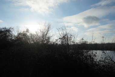 Low winter sun over Biesdorfer Baggersee lake in January. Berlin, Germany