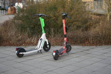 Almanya 'da araçlar. Ocak ayında yol kenarındaki kaldırımda scooterlar. Berlin, Almanya